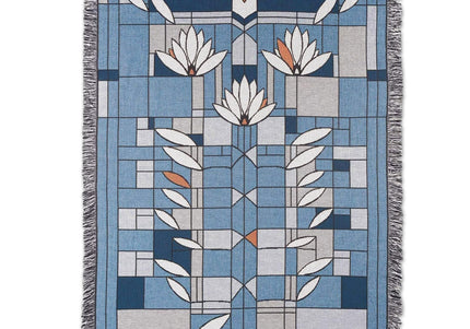 Blanket with fringe featuring primarily blue and white Frank Lloyd Wright floral designs.