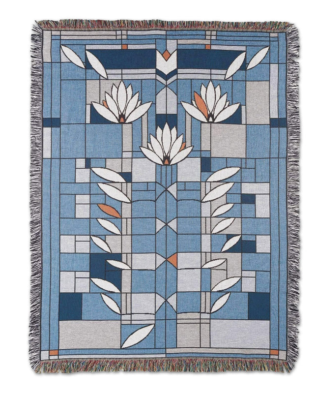 Blanket with fringe featuring primarily blue and white Frank Lloyd Wright floral designs.