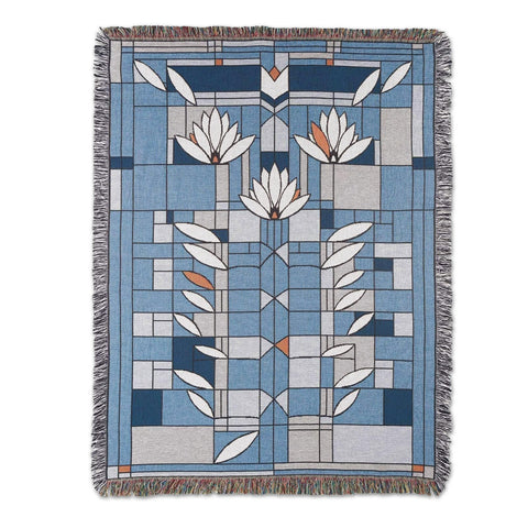Blanket with fringe featuring primarily blue and white Frank Lloyd Wright floral designs.