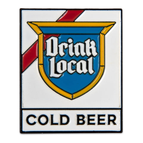Enamel pin with 'DRINK LOCAL' and 'COLD BEER' text in a shield shape on a white background, with a red stripe at the top.