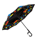 A colorful, patterned reverse umbrella inspired by Frank Lloyd Wright, with a black handle.