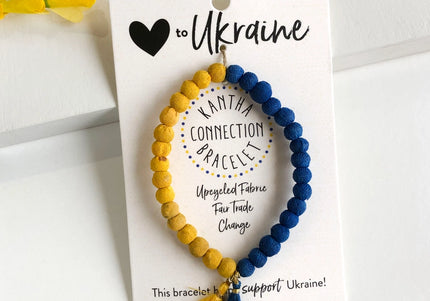 A bracelet with blue and yellow beads, and a tassel, displayed on a card with text supporting Ukraine.