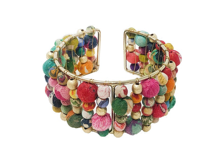 A colorful beaded cuff bracelet made from layers of Kantha beads with gold accents, displayed against a white background.