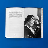 Open book showing a black and white photograph of two men on a blue background