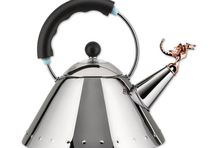 A silver stainless steel tea kettle with a black handle and a copper metallic finish whistle shaped like a t-rex.