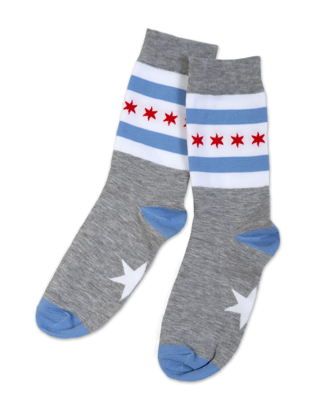 A pair of grey socks with the Chicago flag design elements of blue and red stripes and a star shape on the sole.