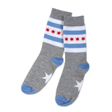 A pair of grey socks with the Chicago flag design elements of blue and red stripes and a star shape on the sole.